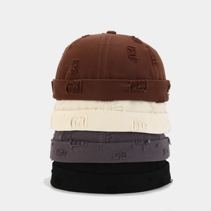 Distressed cotton brimless docker caps in brown, cream, grey and black stacked vertically