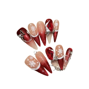 Handmade Christmas press-on nails with red glitter, snowflake art, and ruby gems