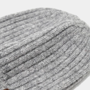 Macro shot of gray chunky ribbed knit beanie showing soft wool blend fabric texture