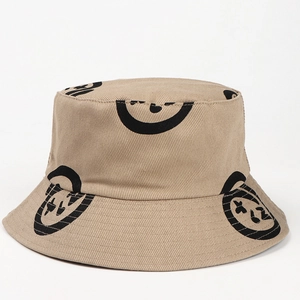Close-up of khaki twill fabric and black abstract smiley face print on fisherman hat