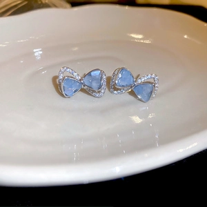 Vue macro de boucles d'oreilles papillon bleu clair avec cadre argenté et zircon