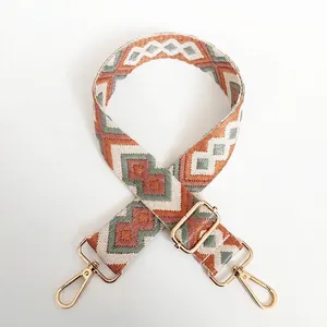 Detail of colorful geometric diamond pattern canvas bag strap with gold metal hooks