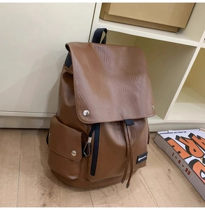 Vista dettagliata di uno zaino in ecopelle marrone con coulisse e tasche con fibbia argento