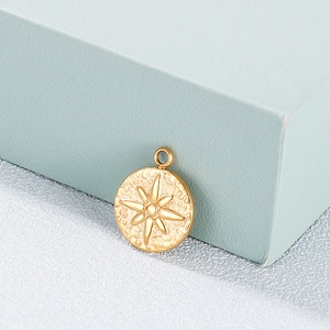 Macro view of gold round stainless steel pendant with engraved star and retro texture
