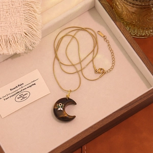 Collana a catena serpente dorata con ciondolo a mezzaluna in pietra e dettaglio a farfalla