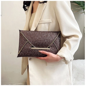 Détail de la pochette enveloppe pailletée avec bordure dorée et fermoir à pression