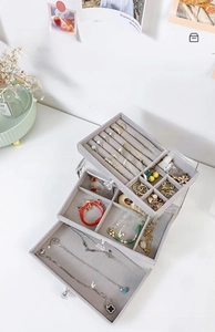 Three-layer clear jewelry box with grey velvet compartments for rings and necklaces