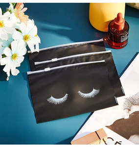 Three black eyelash storage bags with zipper, displayed with cosmetics and accessories