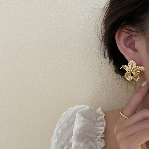 Large golden flower earrings with textured petals in an elegant French style look