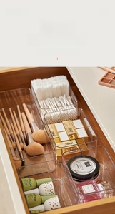 Macro shot of multi-size transparent acrylic organizers in a wooden storage drawer