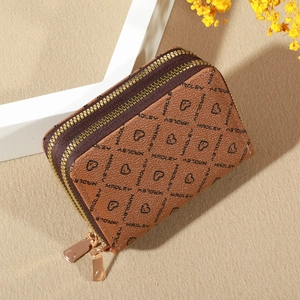 Close-up of brown textured leather coin purse with double gold zippers and heart pattern