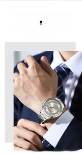 Close-up of a silver business watch with dual calendar display on a man's wrist
