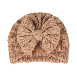 Détail du bonnet turban pour bébé en maille torsadée camel avec un grand nœud
