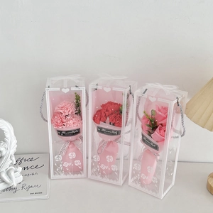 Three assorted soap flower bouquets in transparent gift boxes with elegant ribbon detailing