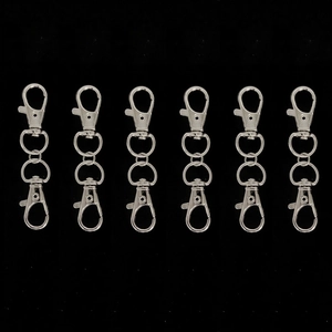 Close-up of six silver alloy swivel lobster clasps for DIY keychain making on black background