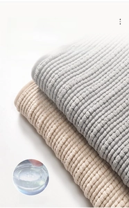Detail of chenille bath mat with anti-slip hot melt adhesive backing on gray and beige fabric
