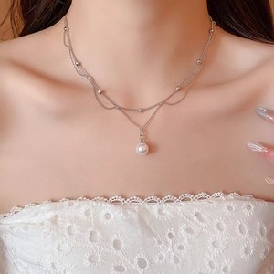 Gros plan du collier double épaisseur en argent avec perle ronde sur un mannequin