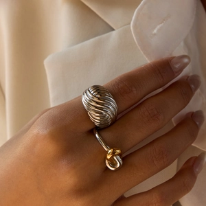 Minimalist silver wide spiral ring and two-tone gold knot ring set on hand