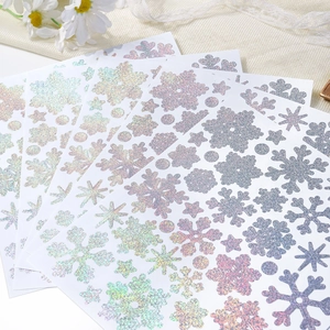 Detail of glitter snowflake stickers with holographic finish on a decorative mesh background