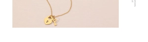 Vue macro d'un pendentif serrure cœur et clé dorée sur une chaîne en acier inox