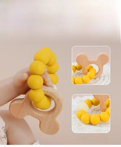 Detail of smooth beech wood and yellow silicone beads on infant teething ring