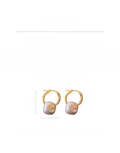 Détail de boucles d'oreilles plaquées or 18k avec perle et zircone pesant environ 8,7g