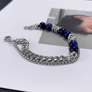 Detail of silver stainless steel double chain bracelet featuring blue tiger eye beads