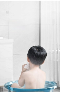 Baignoire bébé bleue translucide dans une salle de bain avec fond en marbre chic