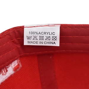 Macro view of red baseball cap inner lining with 100% acrylic fabric and wash label