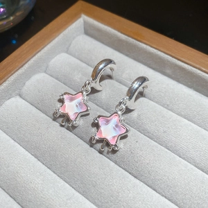 Detailed macro shot of silver star-shaped resin pendant earrings with sparkling crystals