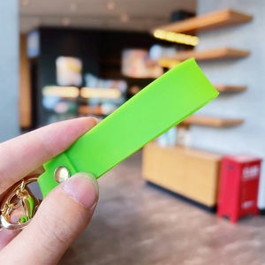 Detail of neon green silicone lanyard with golden metal clasp and ring for panda keychain
