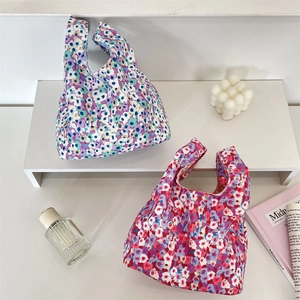 Detail view of corduroy floral wrist bags displayed with aesthetic lifestyle props