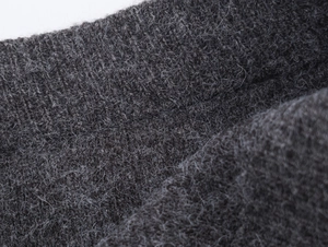 Macro shot of dark grey knit fabric texture showing high-quality wool fiber details