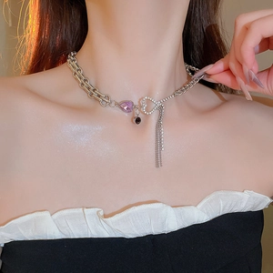 Detail of silver chain necklace with purple heart pendant and sparkling zircon tassels