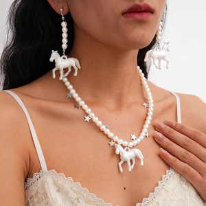Vue détaillée du collier en perles avec pendentif cheval iridescent et étoiles argentées