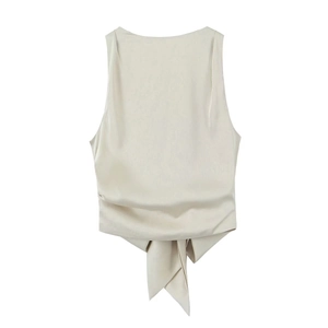 Detail von champagnerfarbenem Satin-Crop-Top mit Bindedetail und Falten am Saum