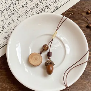 Détail d'un collier vintage en bois avec pendentif rond et gland sur un plat
