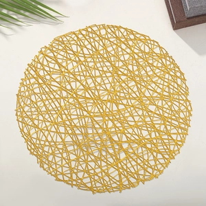 Close-up of a circular gold PVC cutout placemat with a shiny metallic woven texture
