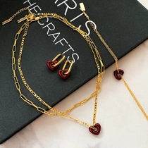 Macro shot of gold necklace with red heart pendants and matching jewelry set