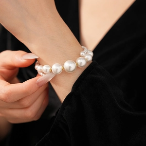 Détail d'un bracelet de perles double couche avec perles dorées sur velours noir chic