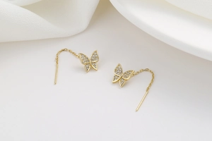 Detail of elegant gold butterfly threader earrings with shimmering pave zircon stones