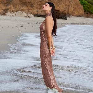 Close-up of sparkling rose gold sequins and elegant backless detail on a slim fit maxi dress
