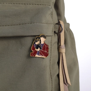 Anime enamel pin featuring a faceless character with pet on a green nylon backpack