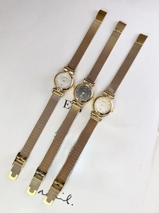 Flat lay of vintage gold mesh strap quartz watches with white and black dials