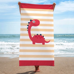 Detail of a microfiber beach towel with dinosaur print and red stripes on a beach background