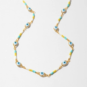 Detail of bohemian evil eye beaded necklace with colorful stones and gold clasp