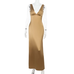 Close-up of elegant gold satin dress with deep V-neckline and delicate beaded chain detail