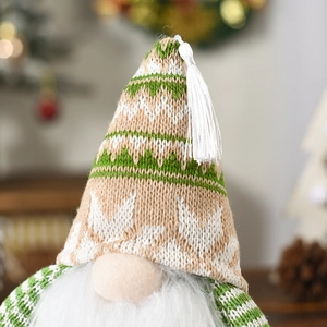 Close-up of knit Christmas gnome hat with green stripes, snowflakes and white beard