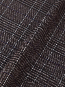 Gros plan d'un tissu à carreaux marron et noir montrant une texture de tissage fine
