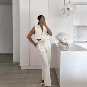 Women's white two-piece set featuring sleeveless crop vest, wide-leg pants and rose detail